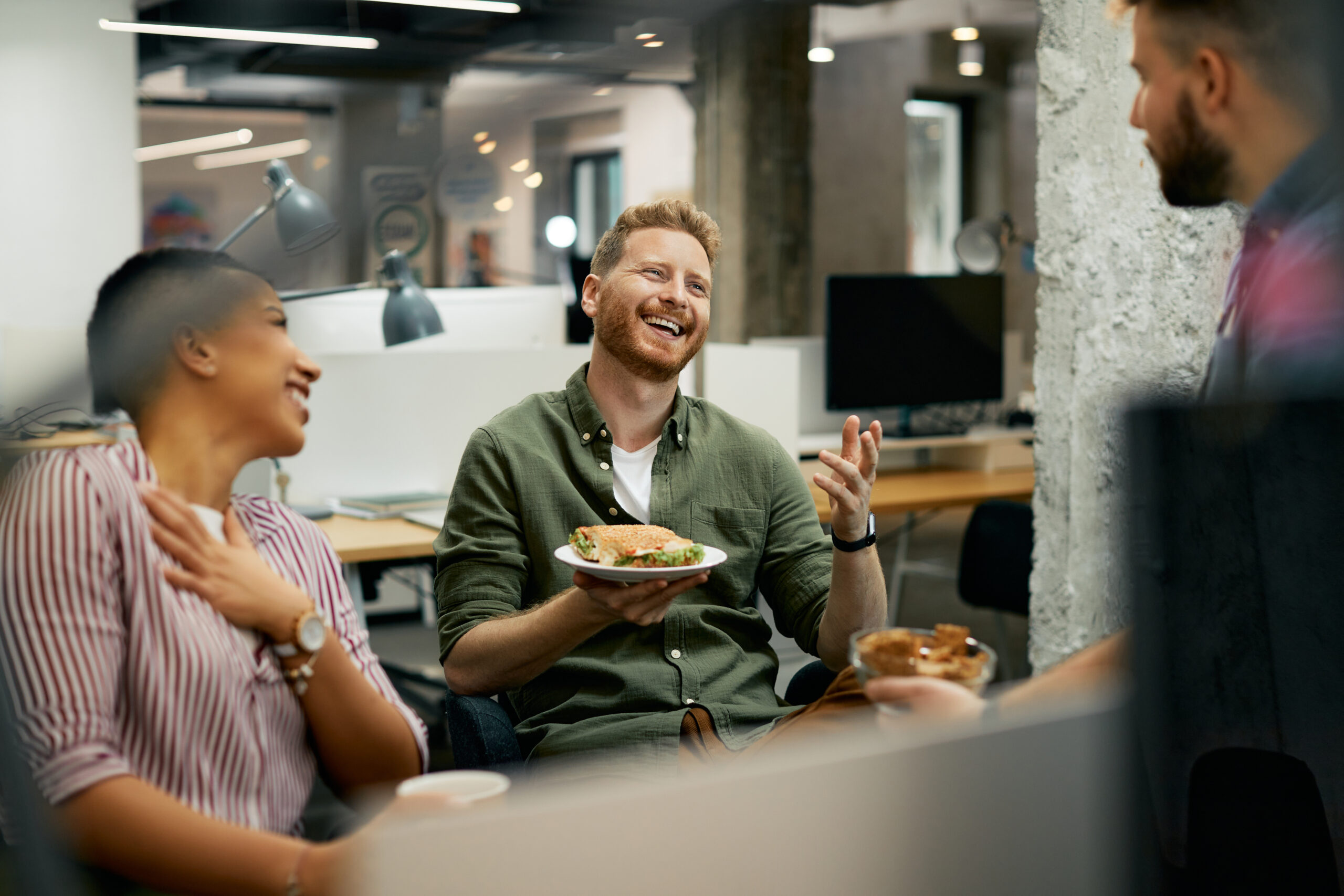 Three people enjoying lunch together in a workplace setting