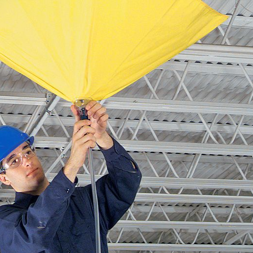 Man fixing a yellow leak diverter tarp to the ceiling 