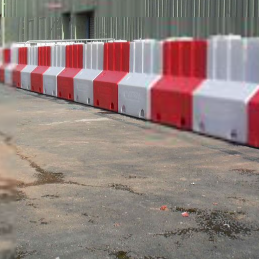 Red and white flood barrier running along a warehouse